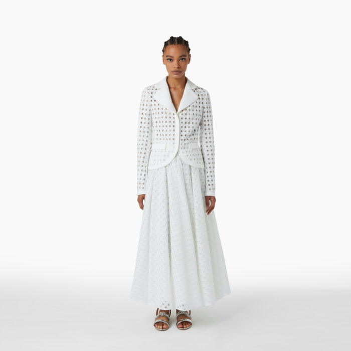 Femme noire posant de face dans une veste blanche en macramé